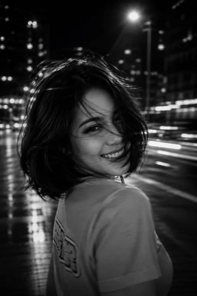 Black-and-white cinematic long-exposure portrait of a woman in the city at night - Image prompt preview