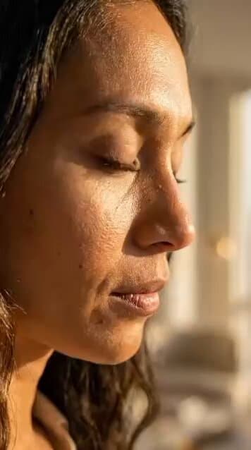 A professional skincare commercial featuring a woman with warm-toned, rad...
