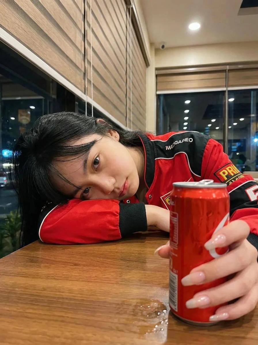 Ultra-realistic photo of a young woman sitting in a cozy café at night, r...