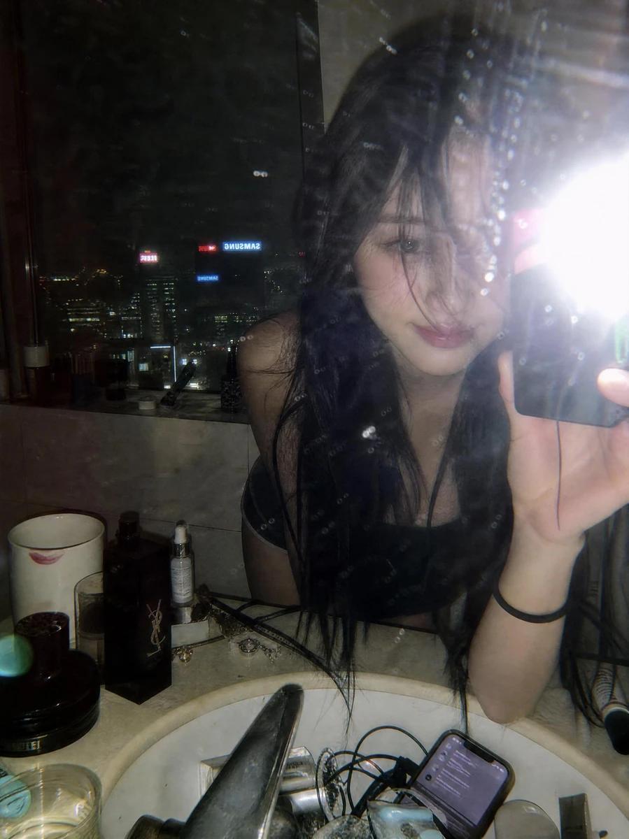 A moody late-night mirror selfie captured in a luxury high-rise bathroom...