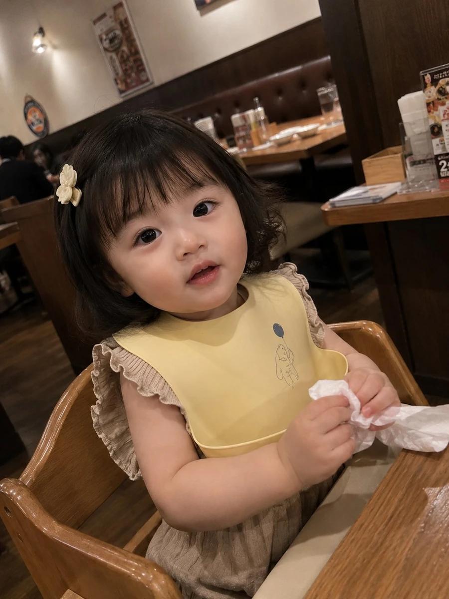 Photorealistic candid smartphone snapshot of an adorable toddler girl sit...