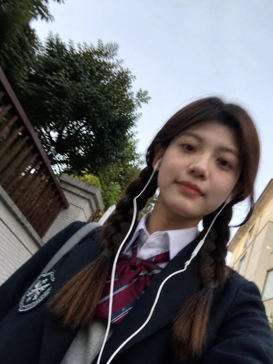 A rough phone-photo selfie of a person, with slight motion blur on the fa...