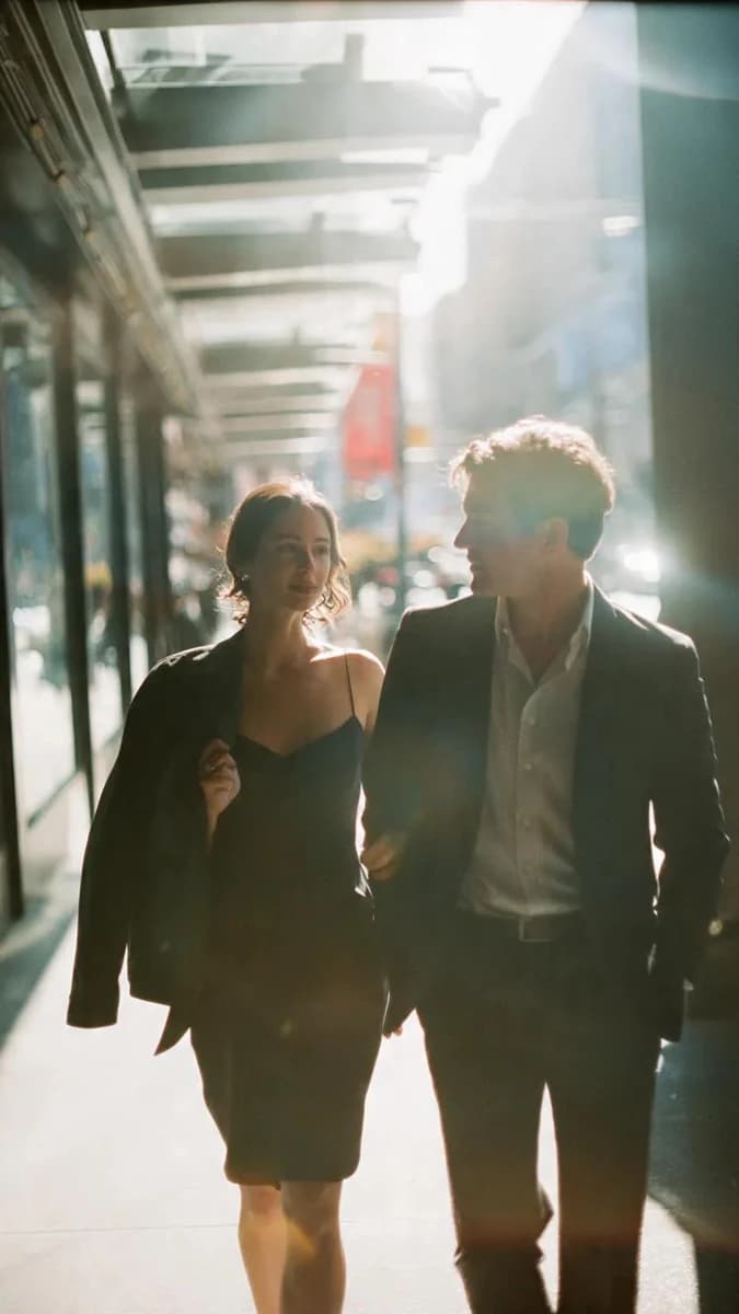 A cinematic candid medium shot portrait of a man and a woman walking side...