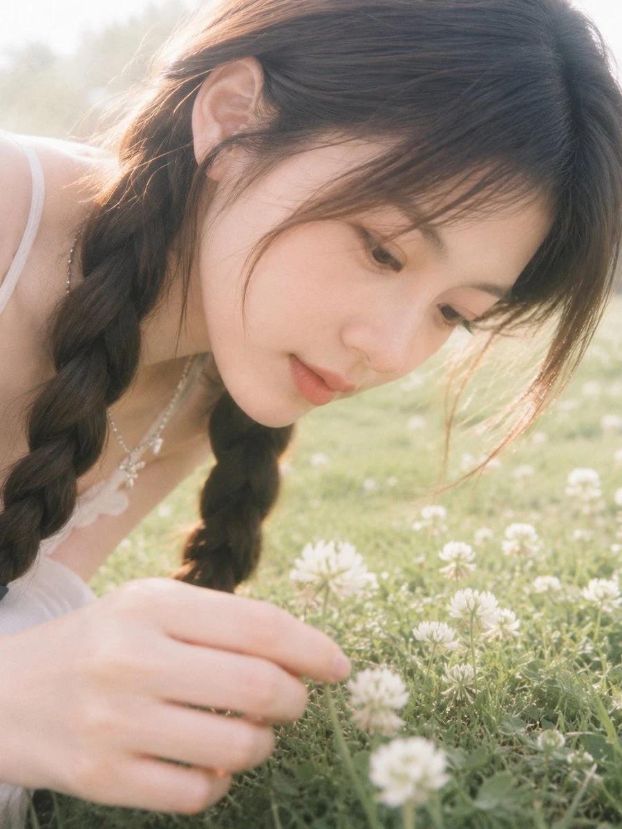 A soft-focus film-style portrait in a spring clover field