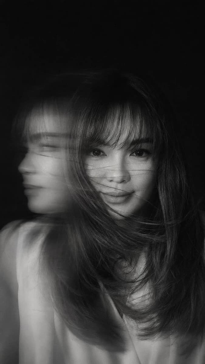 A hyper-realistic, cinematic black-and-white portrait of a woman caught i...