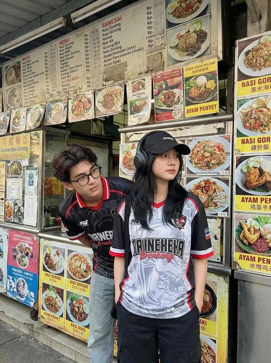 A candid street photography shot of two young Asian adults standing in fr...