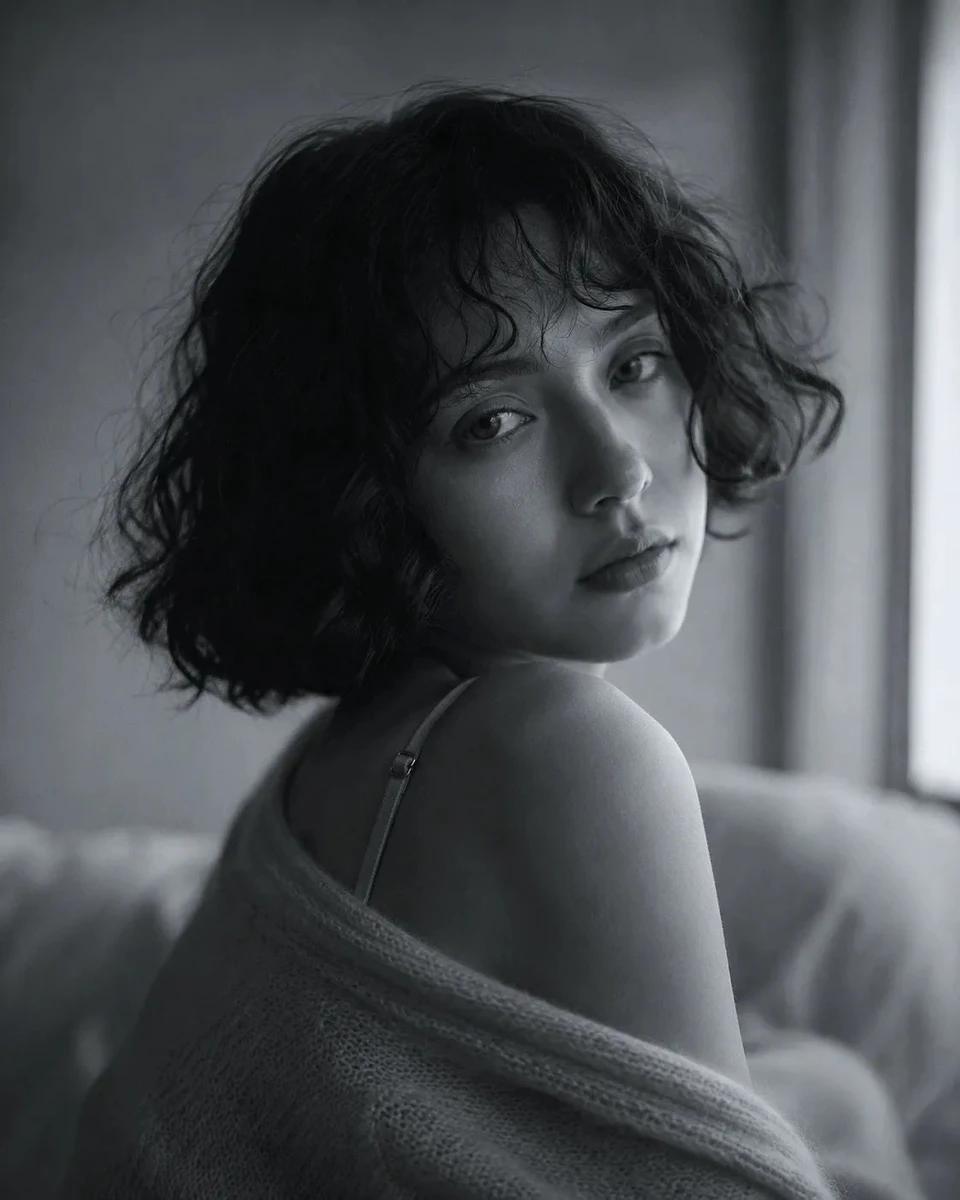 Ethereal fine-art black and white portrait of a young woman with a short...